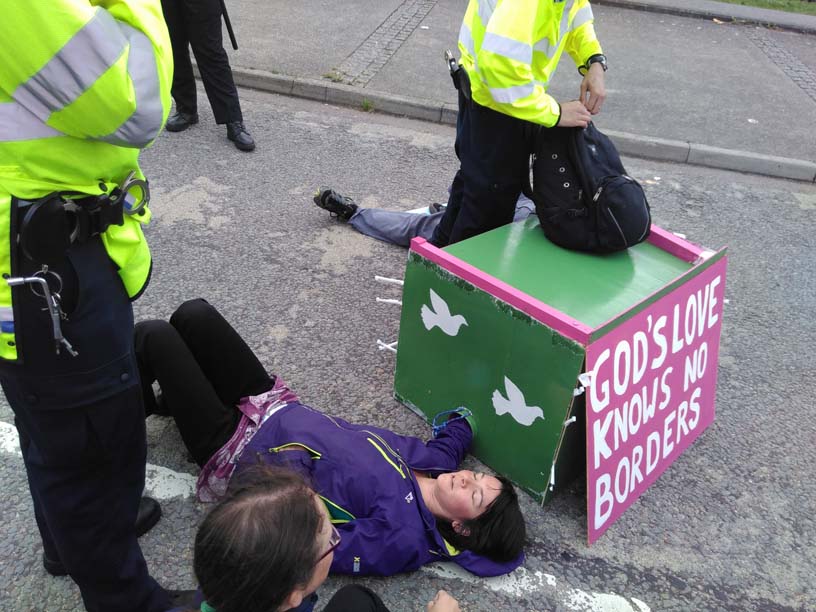 woman lies on ground surrounded by police