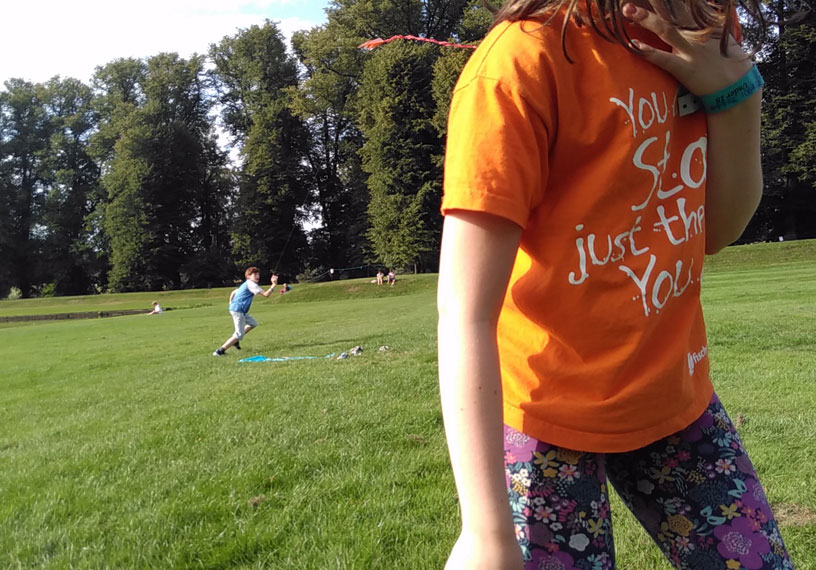 Child in orange t-shirt on grass