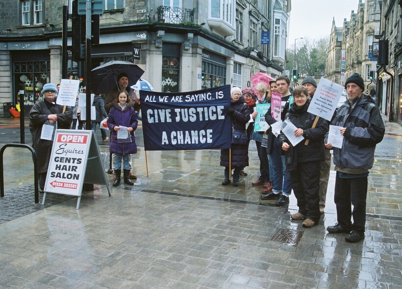 Quakers standing in High Street with flyers about inequality