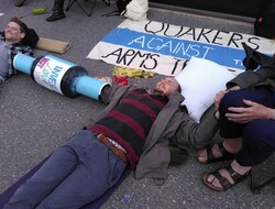 Sam Donaldson lies on the road outside Atomic Weapons Establishment, Burghfield, connected to other protesters