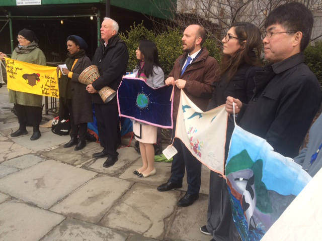 In a vigil, standing outside the UN, seven people with banners against nuclear weapons