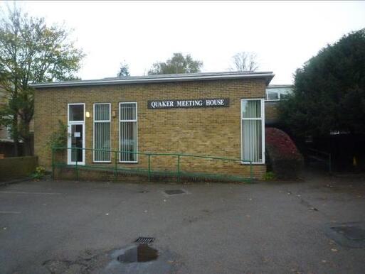 Square brick building with access slope within car park.