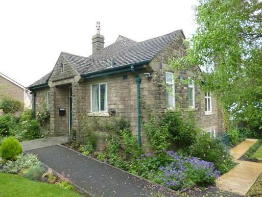 Attractive compact stone building with well-tended garden and stone walls.