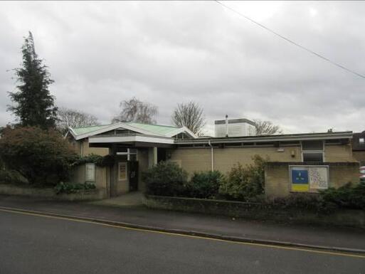 Hexagonal form design with a copper roof building with a sign on wall.