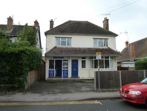 Simple detached white house with blue doors.