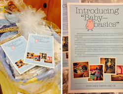 A Moses basket filled with items for children and a copy of a leaflet about 'Baby Basics'