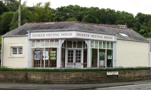 White building with sign 'Quaker Meeting House' above window.