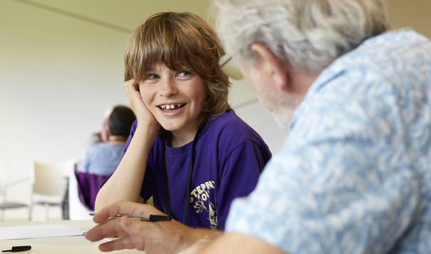 Child smiling and listening to an older person
