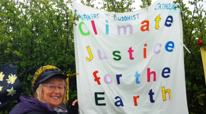 A quaker holds an interfaith banner