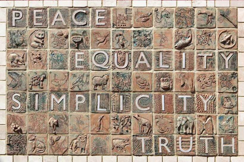 A mosaic in light brown colours includes the words peace, justice, equality and simplicity.