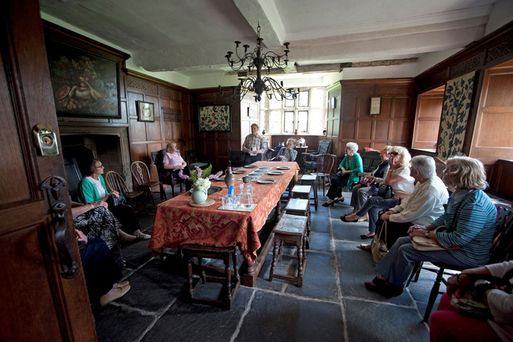 Group of people in a circle in an old room with seventeenth century furniture