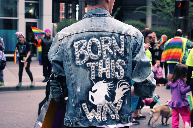 Person wearing a jacket with the words "Born this way" written on it.
