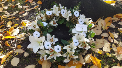 wreath of white flowers including lilies and paper white poppies