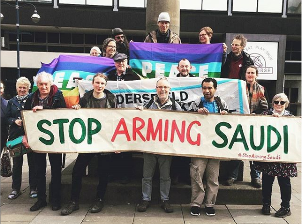 Huddersiefl Quakers standing around a banner saying Stop Arming Saudi