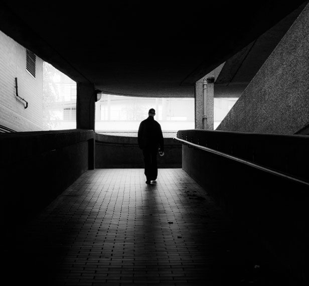 figure walking from dark subway to light