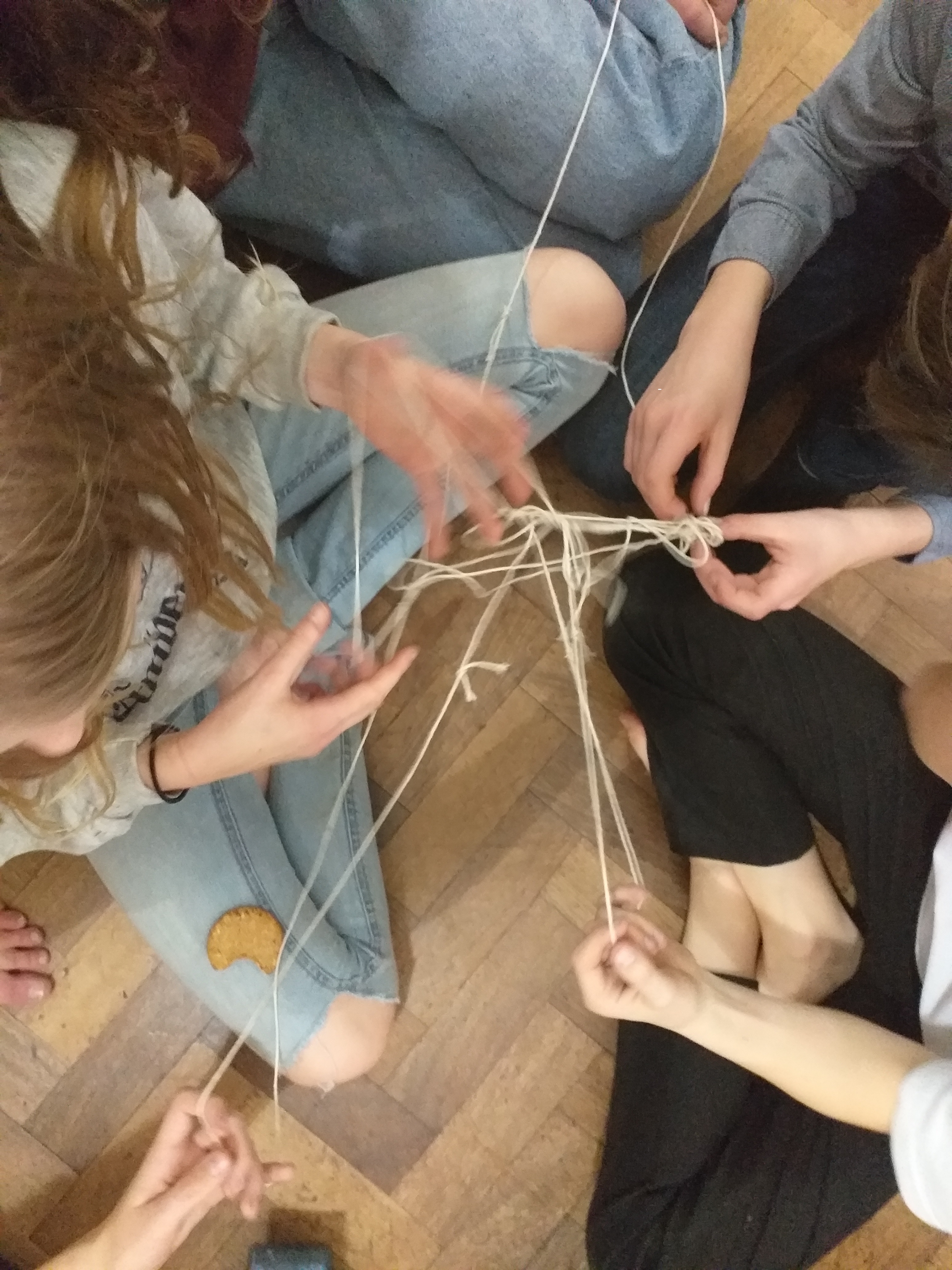 young people playing a game with string