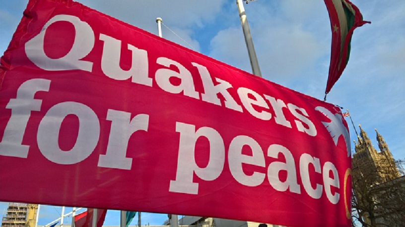 Bright pink banner says Quakers for peace