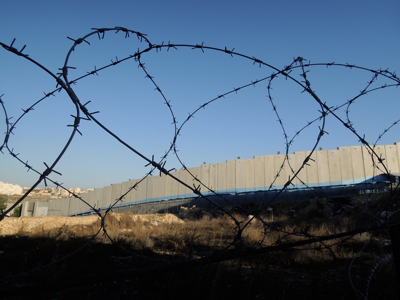razor wire, separation barrier and blue skies