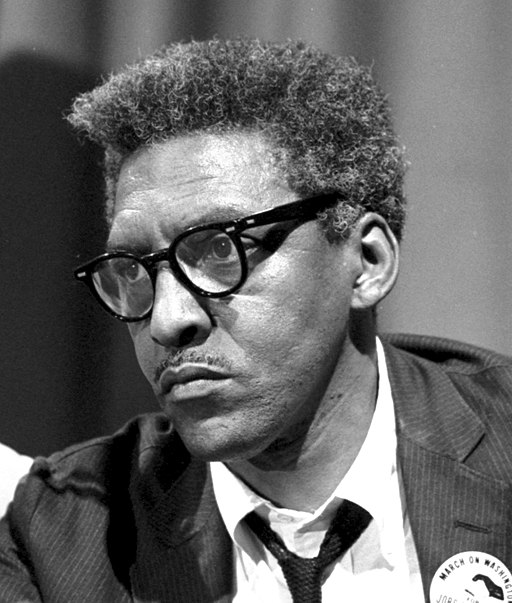 image of the Quaker Bayard Rustin in front of a sign that reads 'integration means better schools for all'