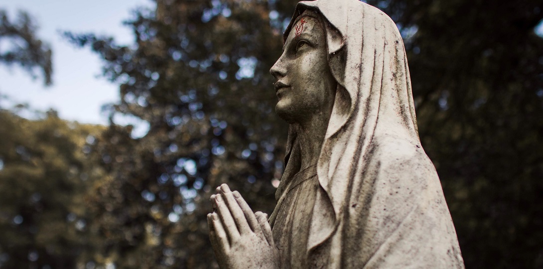 An outdoor statue of Mary praying