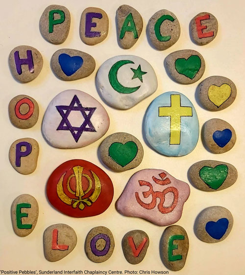 Positive Pebbles at Sunderland Interfaith Chaplaincy Centre shows painted pebbles with symbols from different religions and the words hope, peace and love