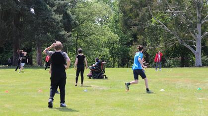 Young people playing capture the flag outside on a sunny day