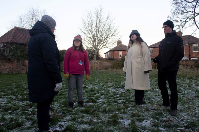 Four people stood on frosted grass