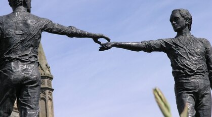 Hands Across the Divide statue of two people reaching out to each other 