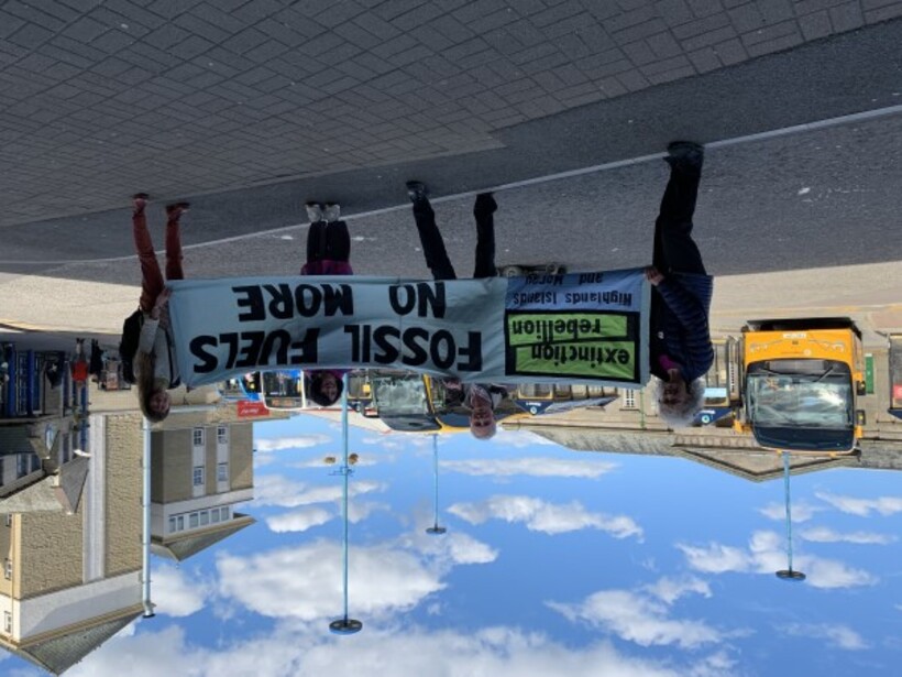 Quakers and Extinction Rebellion activists in Inverness bus station with a banner heading off to London