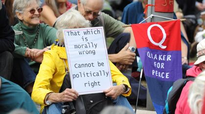 People sitting on the ground in protest. One banner says 'Quakers for peace', another person holds up a sign saying 'that which is morally wrong cannot be politically right' (attributed to multiple people and quoted in Quaker faith & practice 23.26 from a Yearly Meeting minute of 1822)