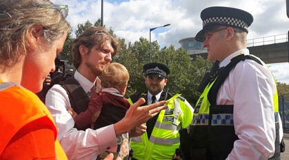 Man with a baby talking to police officers