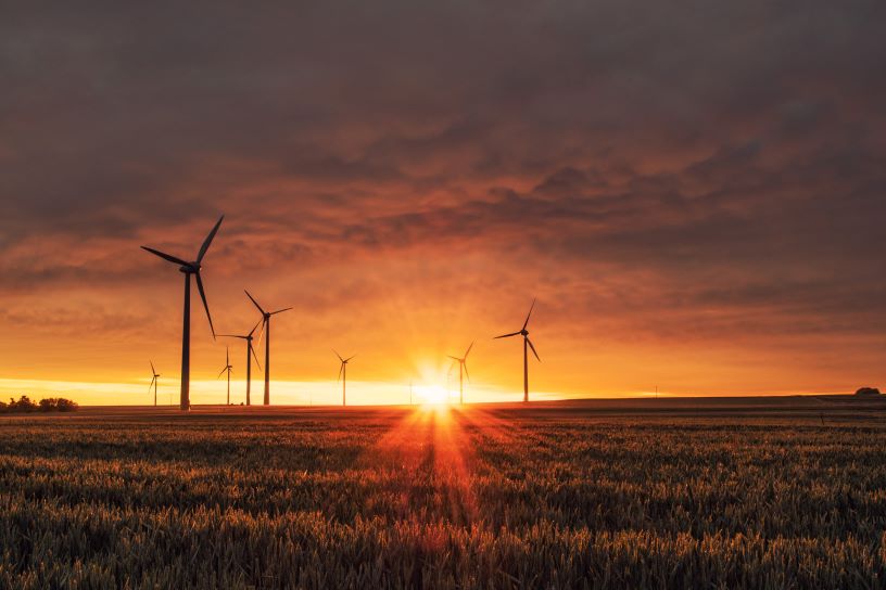 Wind turbines against an orange sunset