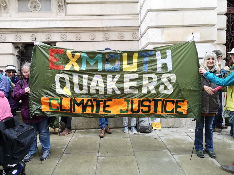 People and colourful banner reading Exmouth Quakers climate justice