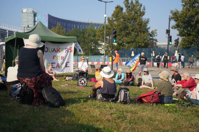 people sitting on grass in worship with banners