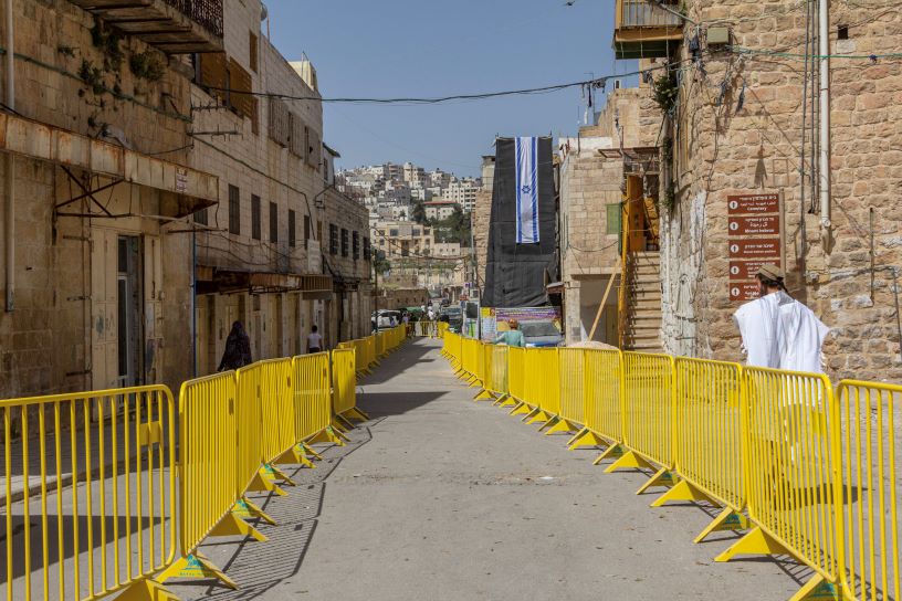 street with yellow crash barriers and an Israeli flag