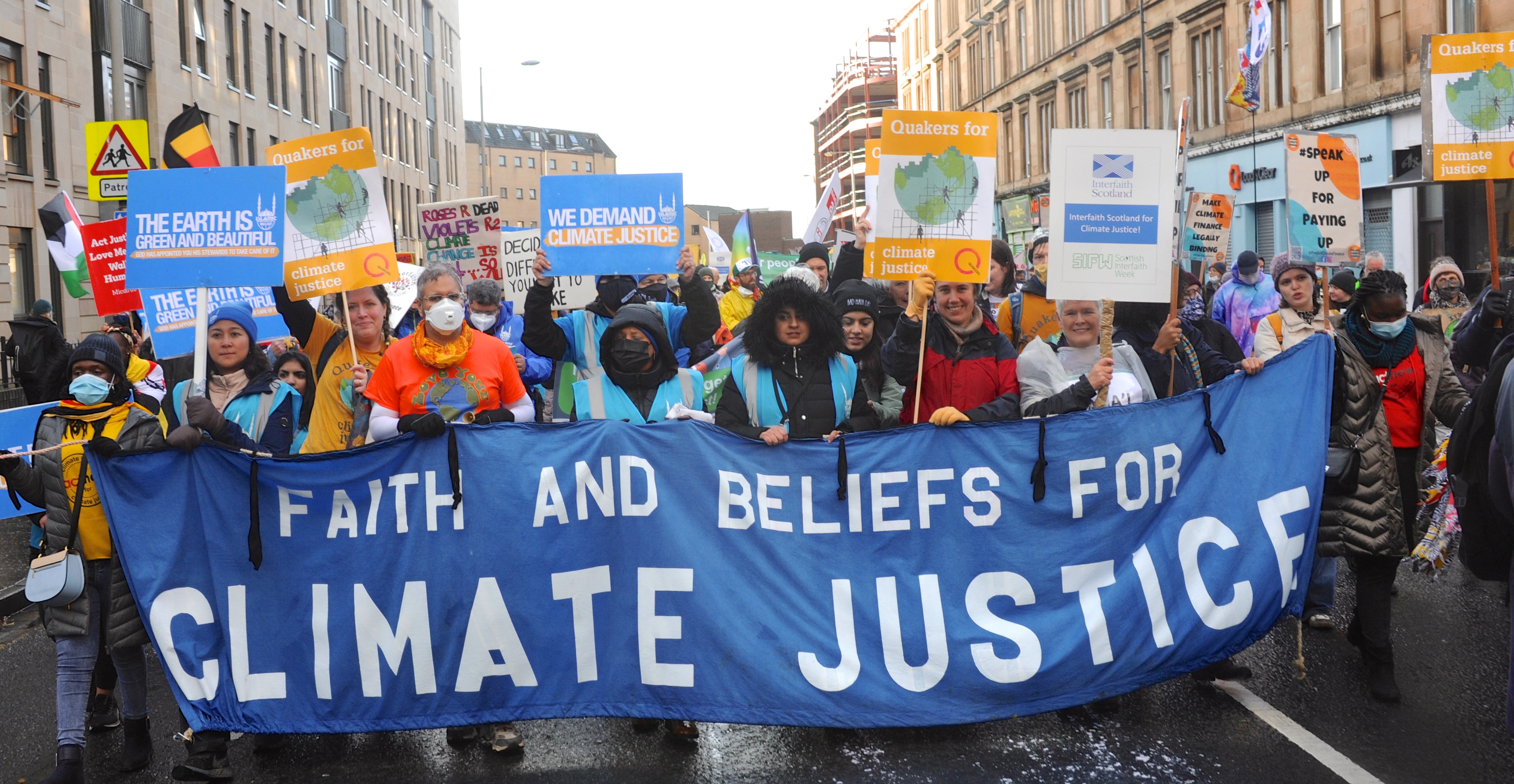 Faith leaders gathered on the street with a banner for climate justice