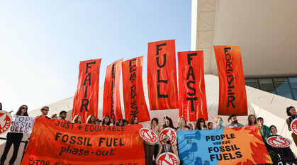 Campaigners at COP28 with banners saying “End Fossil Fuels – Fast, Fair, Forever, Feminist, and Funded
