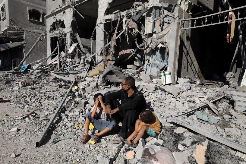 man and two children sitting amongst rubble