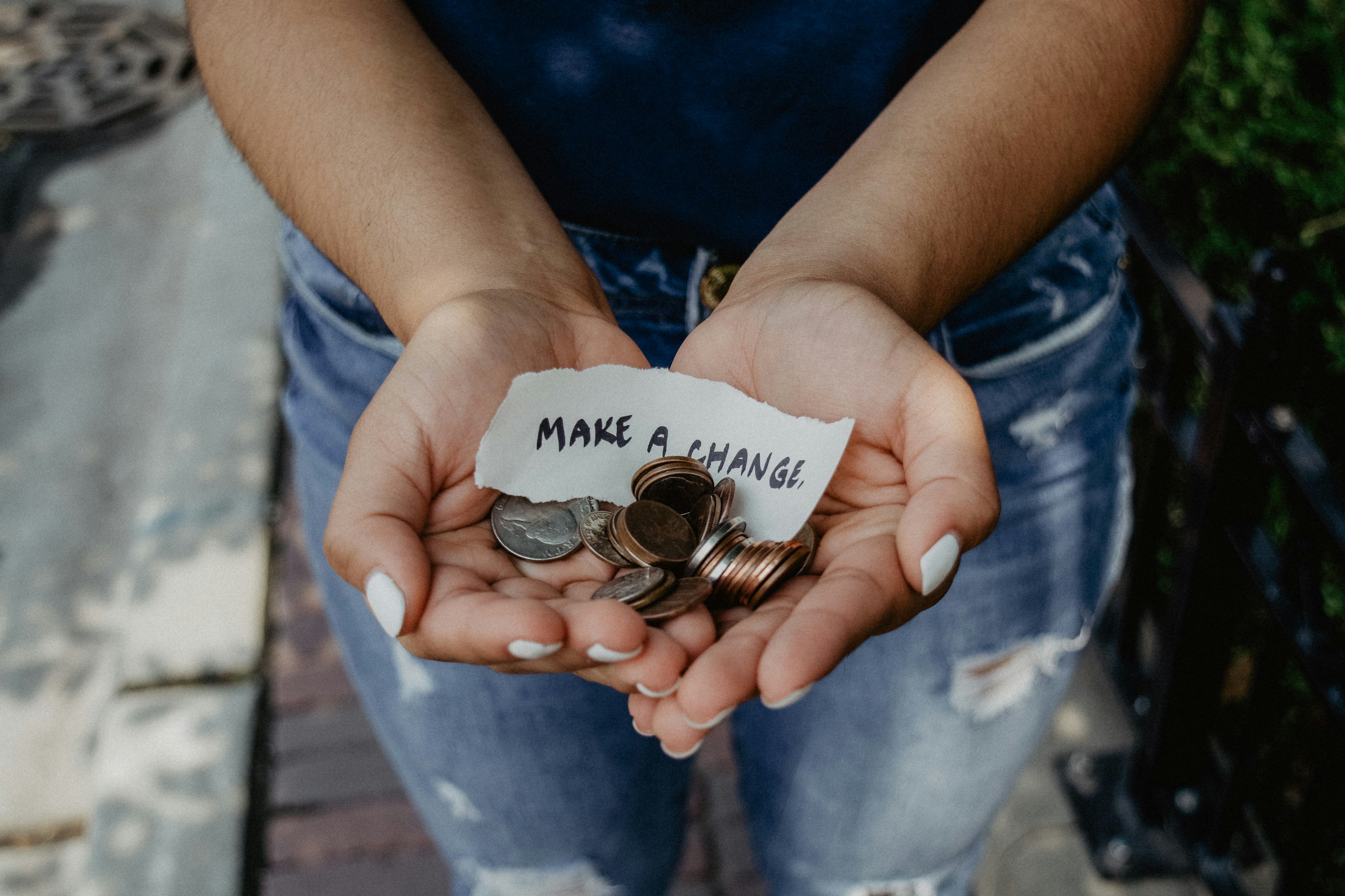 hands holding money with a note saying 'make a change'