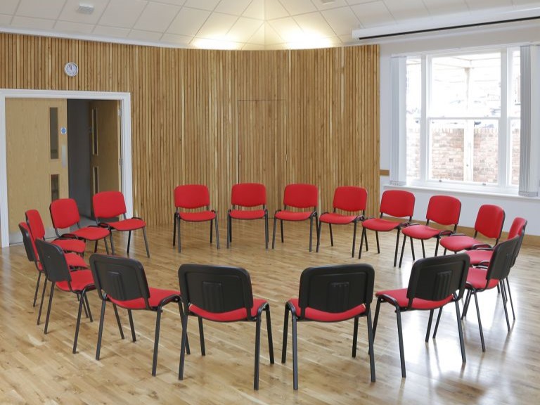 red chairs arranged in a circle on a wooden floor