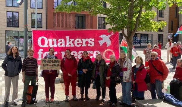 People wearing red in front of Quakers for Peace banner