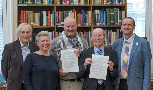 Five people in a row in front of books