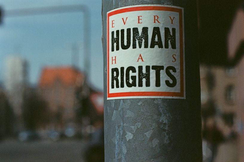 Sticker on metal pole reading 'Every Human Has Rights'