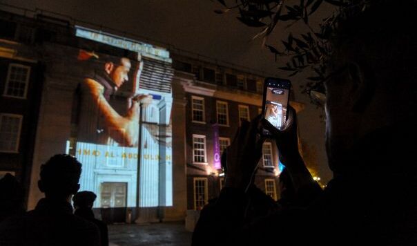 Projection of face on front of building in darkness