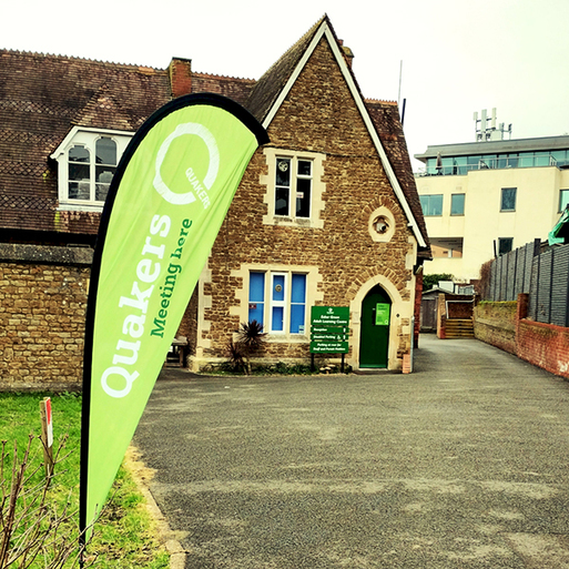 Stone building with arched doorway and green signage