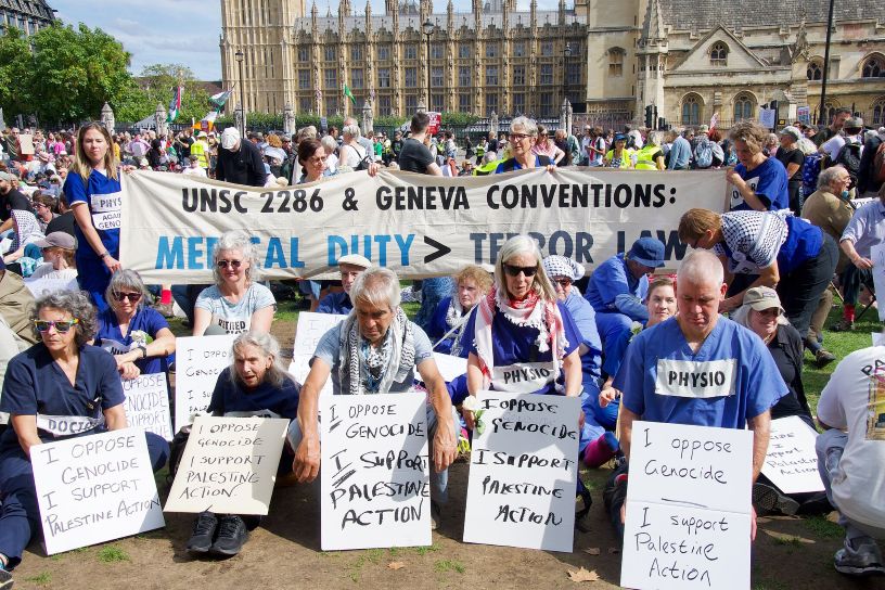 People kneeling holding placards