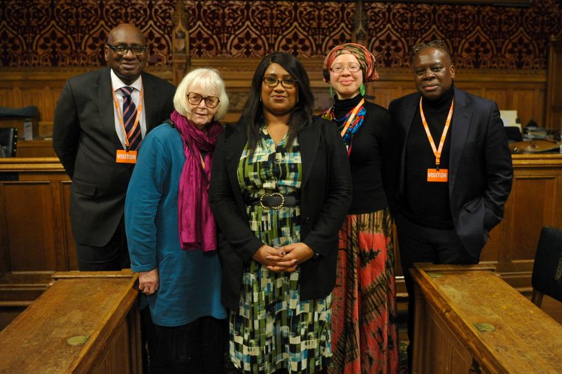 Five people in a row in Parliamentary panelling