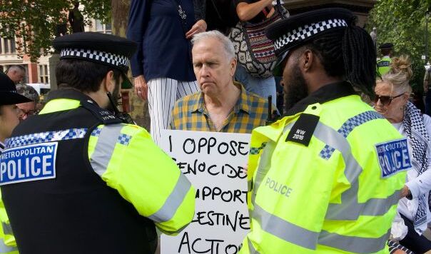 Two policemen and man holding placard