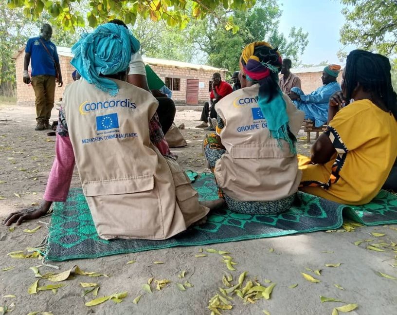 Backs of two women wearing tabards reading Concordis