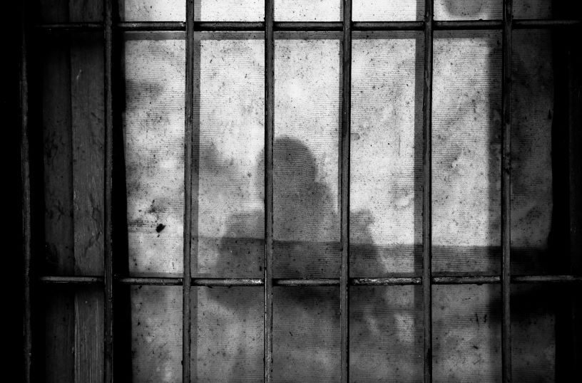 Prison bars and shadow of person